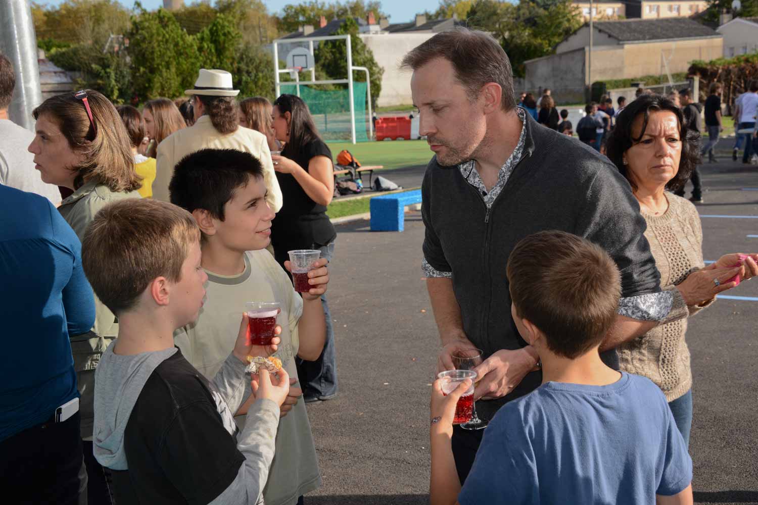 Sympa de discuter avec son professeur un verre (de jus de fruit) à la main dans la cours de récréation
